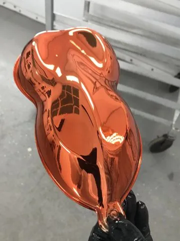 An orange candy chrome panel under the shop lights