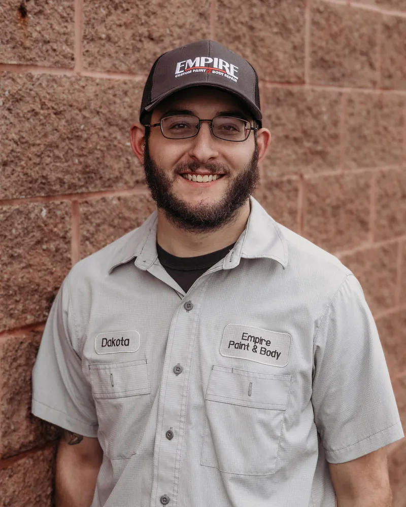 Dakota Nauseef, technician, in an Empire cap and work shirt