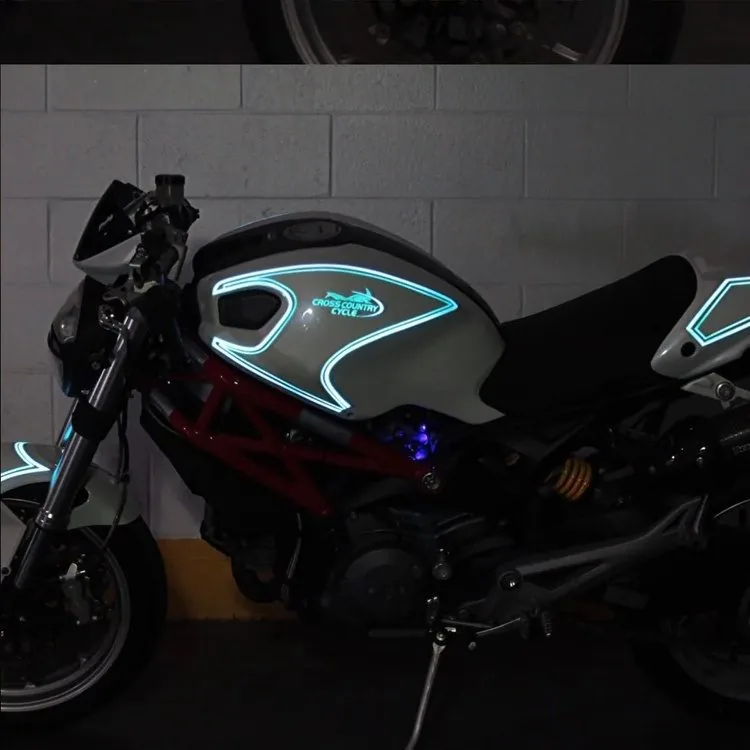 The same Ducati Monster at night with the Lumilor graphics glowing on the tank and tail