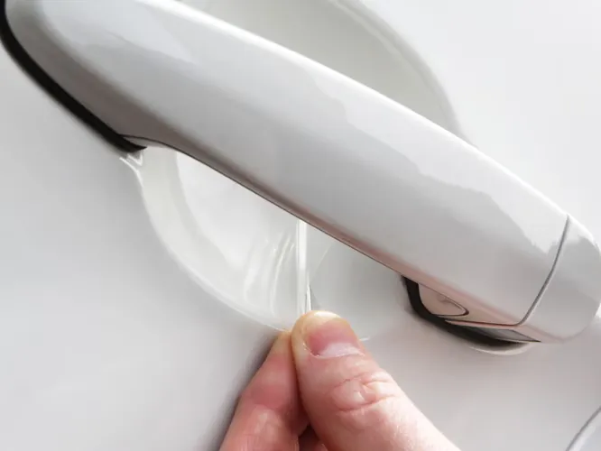 Clear Ricochet film being pressed into the cup behind a door handle (photo: Lamin-x)