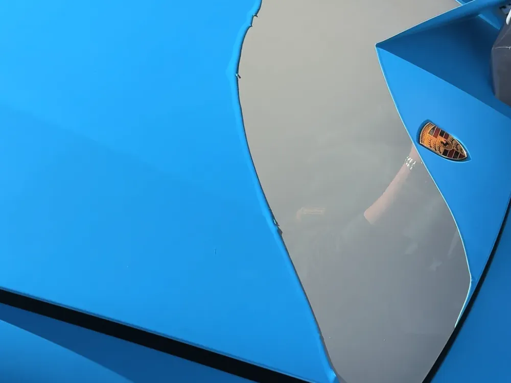 A sheet of blue PeelClear peeling off a car in one piece (photo: PeelClear)